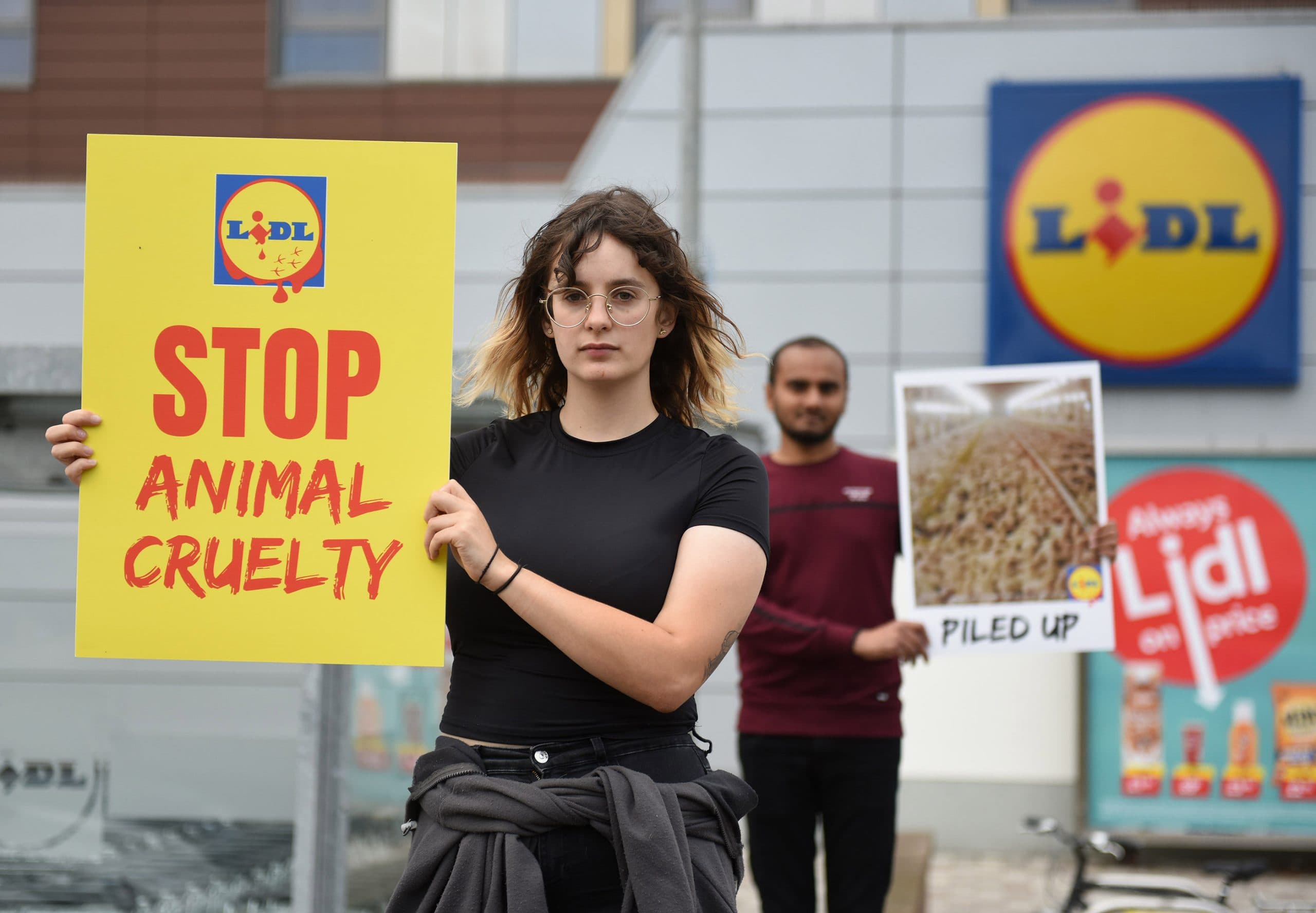 Anima activists holding 'Stop Animal Cruelty' and 'Piled up' signs during a protest outside Lidl against the sale of fast-growing chickens bred to suffer.