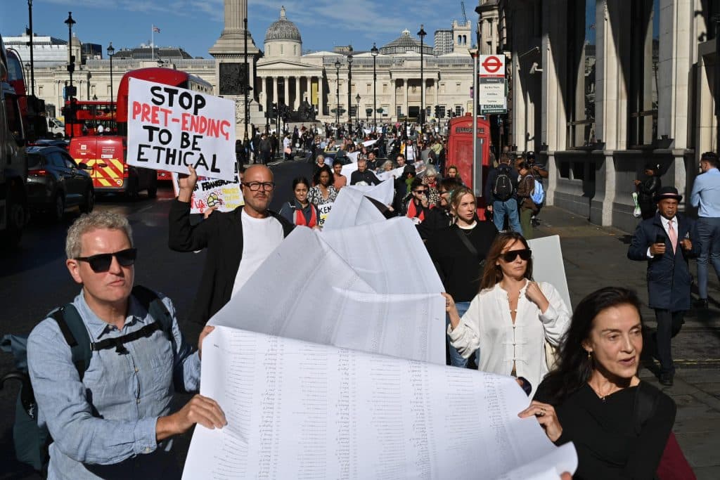 Campaigners march through central London with STOP PRET-ENDING TO BE ETHICAL sign