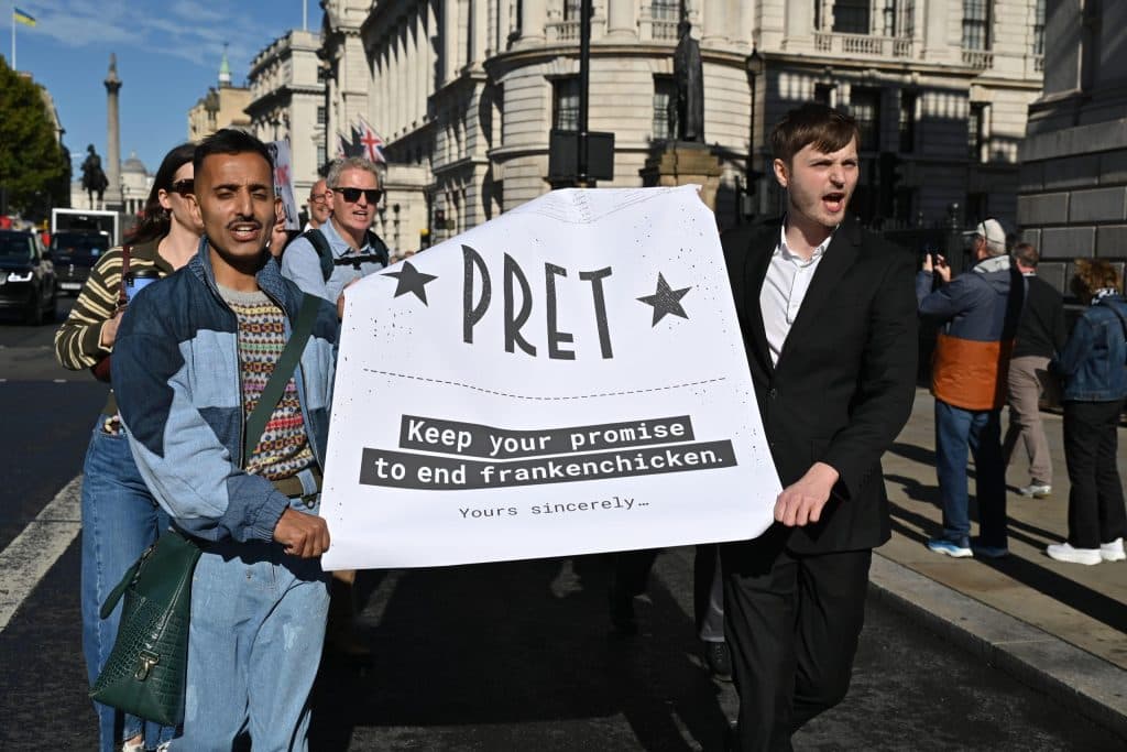 Activists marching with coalition banner: PRET Keep your promise to end frankenchicken