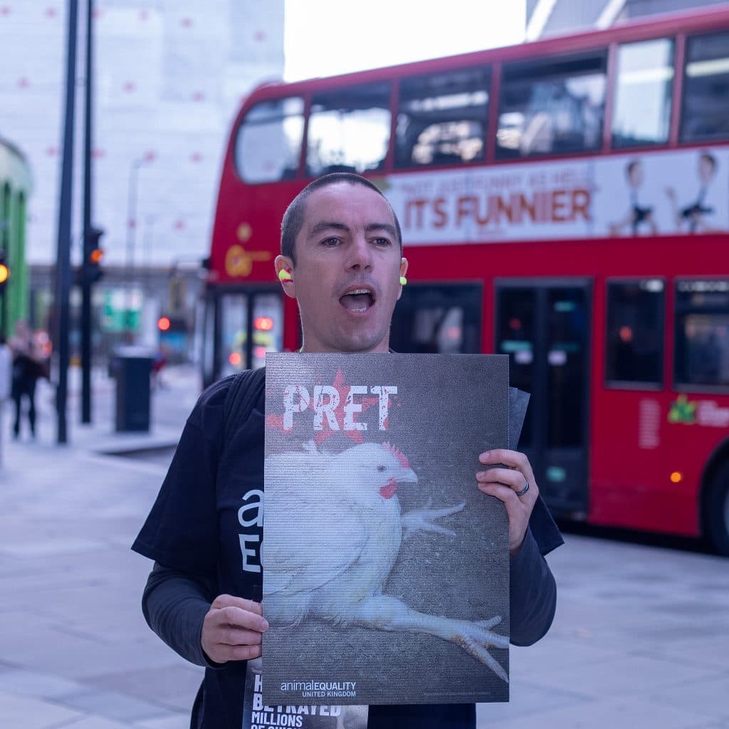 Protester holding sign declaring Pret has betrayed chickens